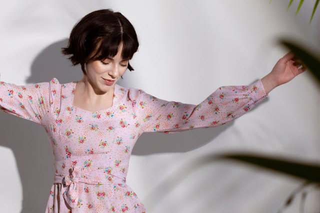 woman in pink dress dances alon indoors