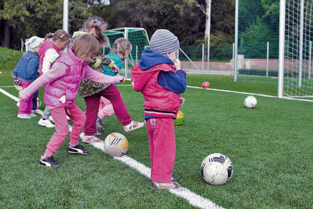 tolders line up near net with soccer balls